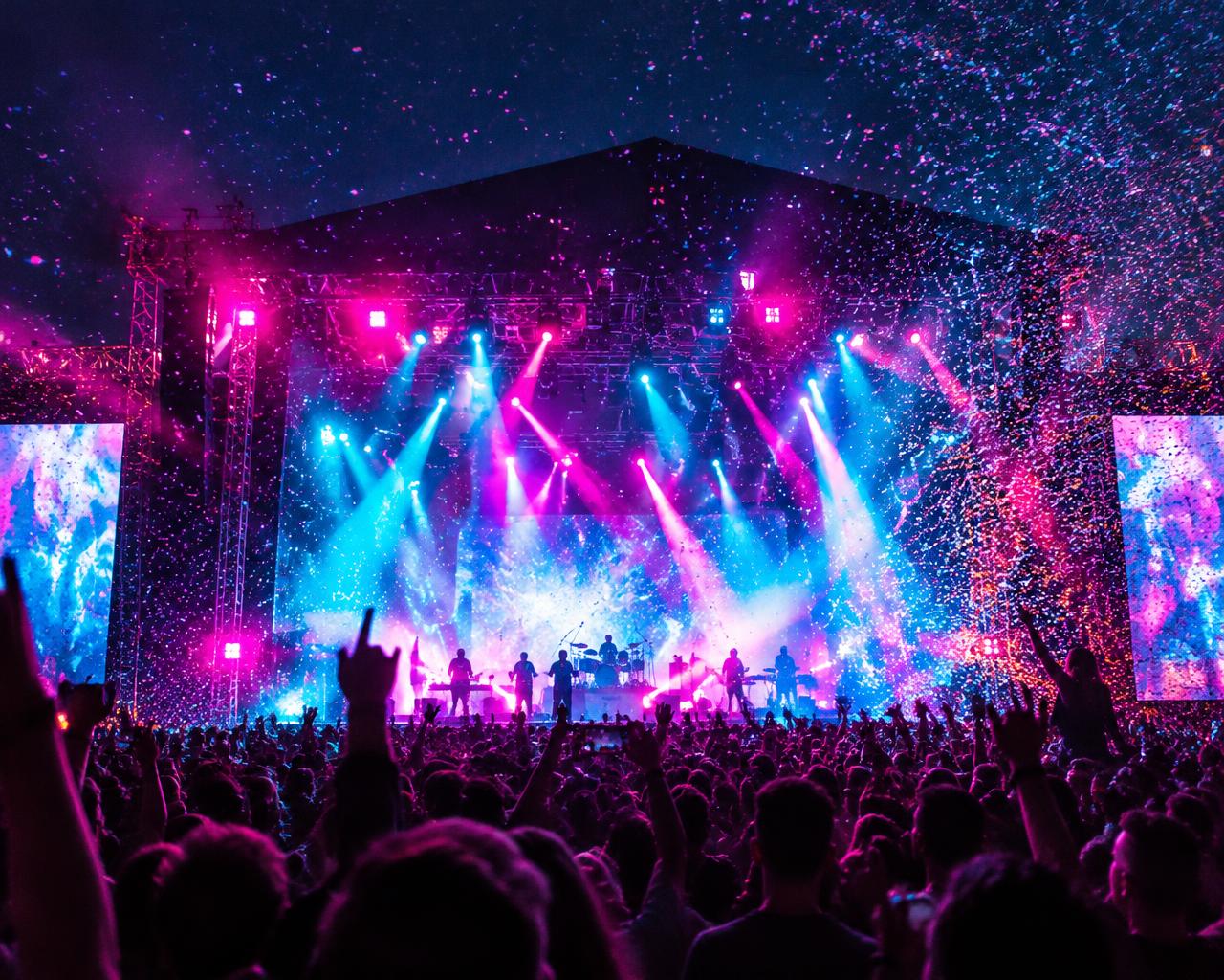 Concert crowd under colourful stage lighting and confetti
